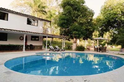 a swimming pool in a yard with a house at Hotel San Sebastian del Tonusco in Santa Fe de Antioquia