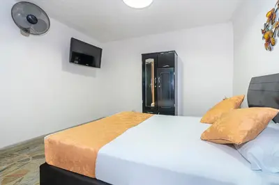 a bedroom with a large white bed with two pillows at Hotel Barcelona Estadio in Medellín