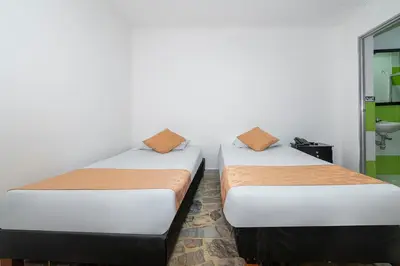 two beds sitting next to each other in a room at Hotel Barcelona Estadio in Medellín