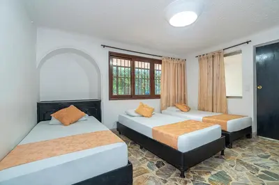 a bedroom with two beds and a window at Hotel Barcelona Estadio in Medellín