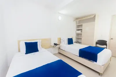 two beds in a room with blue and white at Hotel Suite del Parque in Medellín