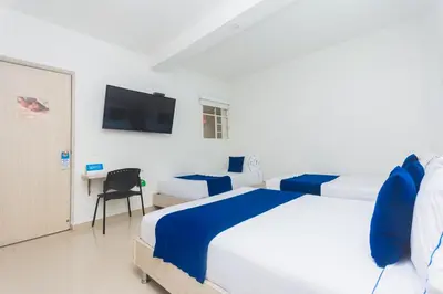 a bedroom with a bed and a desk and a tv at Hotel Suite del Parque in Medellín