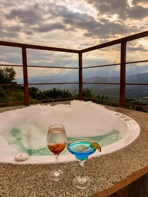 a hot tub with a drink and a glass of wine at Finca Hotel Los Guayacanes in San JosÃ©