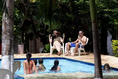 a group of people sitting around a swimming pool at Hosteria El Castellano in Santa Fe de Antioquia