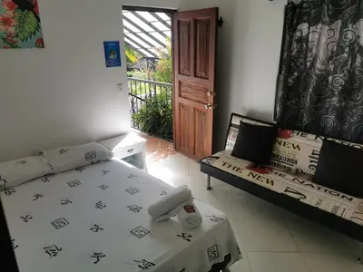a room with a bed and a couch and a door at Hosteria El Castellano in Santa Fe de Antioquia