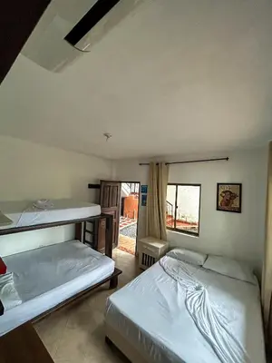 a room with two beds in it with a window at Hosteria El Castellano in Santa Fe de Antioquia