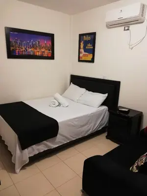 a bedroom with a bed and a air conditioner at Hosteria El Castellano in Santa Fe de Antioquia
