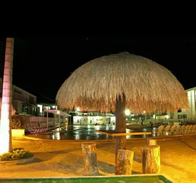 a large straw umbrella in front of a building at Apartasol Santafe de Antioquia in Santa Fe de Antioquia