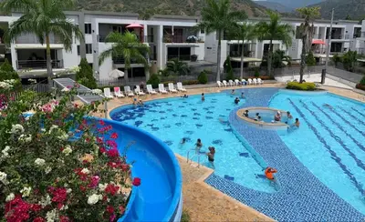 a pool at a hotel with people in it at Apartasol Santafe de Antioquia in Santa Fe de Antioquia