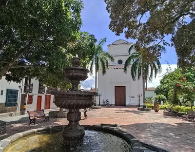 a fountain in front of a building with a church at Hotel Casa de Verano - Solo adultos - in Santa Fe de Antioquia