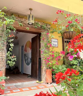 an entrance to a house with flowers and plants at Hotel Casa de Verano - Solo adultos - in Santa Fe de Antioquia
