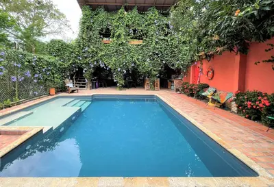 a swimming pool in front of a house at Hotel Casa de Verano - Solo adultos - in Santa Fe de Antioquia