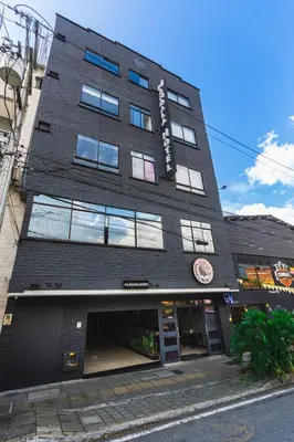a tall black building on a city street at Mandala Medellín Belén By GyC Hotels in Medellín
