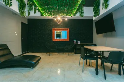 a waiting room with tables and chairs and a mirror at Mandala Medellín Belén By GyC Hotels in Medellín