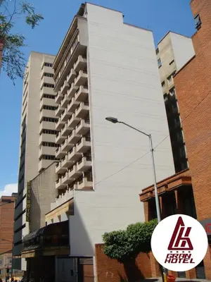 a tall white building with a sign in front of it at Gran Hotel in Medellín