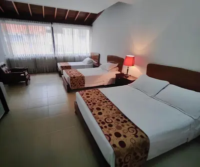 a hotel room with two beds and a couch at Gran Hotel in Medellín
