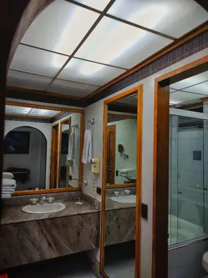 a bathroom with two sinks and two mirrors at Gran Hotel in Medellín