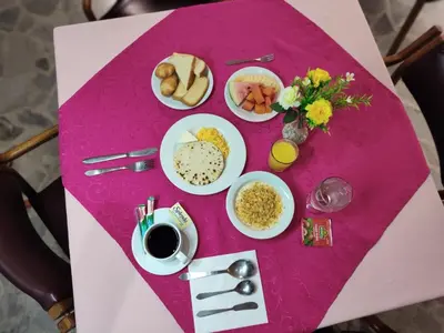 a pink table with plates of food on it at Gran Hotel in Medellín