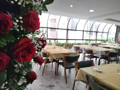 a restaurant with tables and red roses on the wall at Gran Hotel in Medellín