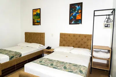 a hotel room with two beds and a mirror at Hotel Central Plaza Medellin in Medellín