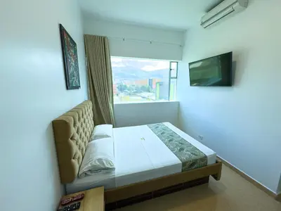 a bedroom with a bed and a large window at Hotel Central Plaza Medellin in Medellín