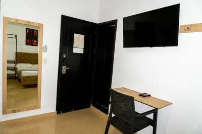 a room with a black door and a table and a mirror at Hotel Central Plaza Medellin in Medellín
