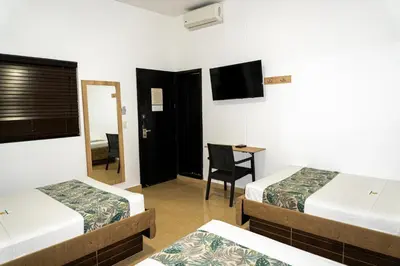 a hotel room with two beds and a television at Hotel Central Plaza Medellin in Medellín