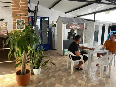 two men sitting at a table in a shop at Hotel Ozzy in Doradal