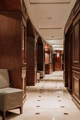 a hallway with wood paneling and a chair in a building at Hotel Park10 in Medellín
