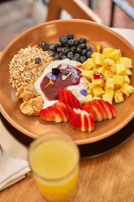 a plate of food with fruit on a table at Hotel Park10 in Medellín