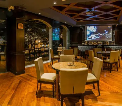 a restaurant with tables and chairs and a tv at Hotel Park10 in Medellín