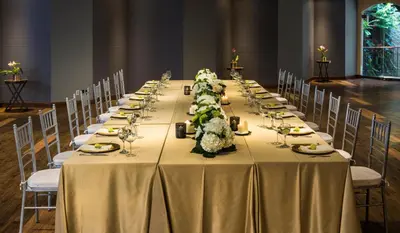 a long table with chairs and a long table with flowers at Hotel Park10 in Medellín