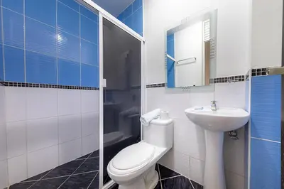 a bathroom with a white toilet and a sink at Hotel Confort Obelisk in Medellín