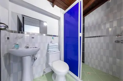 a bathroom with a white toilet and a sink at Hotel Confort Obelisk in Medellín