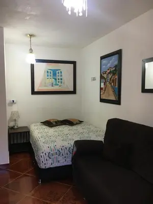 a living room with a bed and a couch at Casa Huespedes EL ENSUEÑO in Jardin