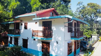 a white house with a red roof at Casa Huespedes EL ENSUEÑO in Jardin