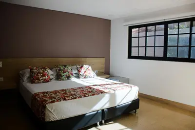 a bedroom with a bed and a window at Hotel Poma Rosa in Medellín