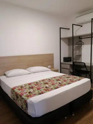 a bedroom with a large bed with a floral blanket at Hotel Poma Rosa in Medellín