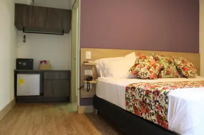 a hotel room with a bed and a television at Hotel Poma Rosa in Medellín