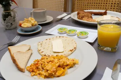 a table with a plate of breakfast food and a glass of orange juice at Hotel Alcaravan Medellín in Medellín