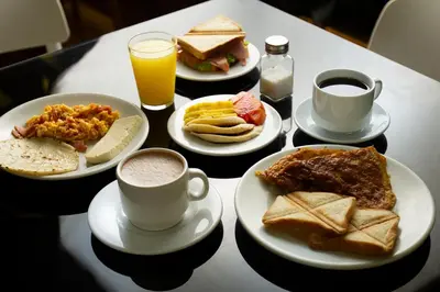 a table with plates of food and cups of coffee at Hotel Veler in Medellín