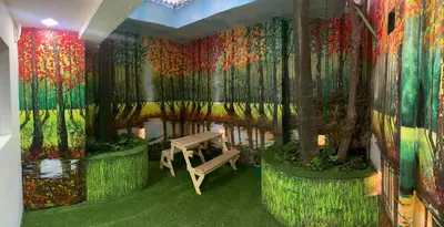 a room with a mural of trees and a bench at Hotel Veler in Medellín