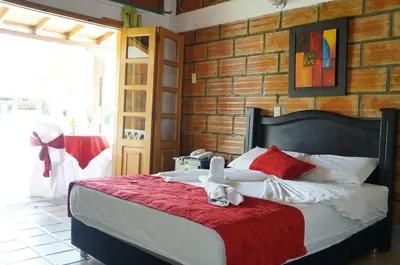 a bedroom with a bed with a stuffed animal on it at Hostería Fundadores in Santa Fe de Antioquia