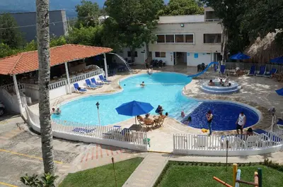 a pool at a hotel with people playing in it at Hostería Fundadores in Santa Fe de Antioquia