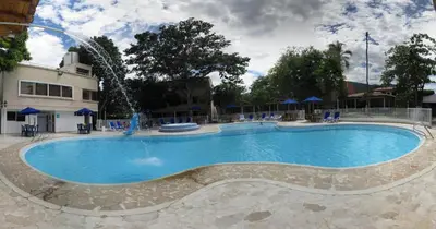 a large swimming pool with a water fountain at Hostería Fundadores in Santa Fe de Antioquia