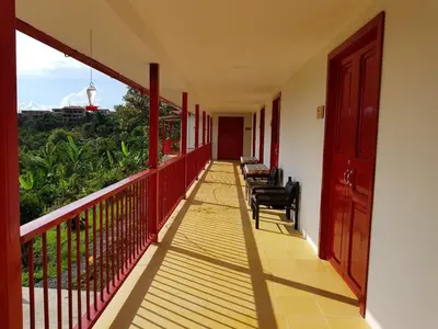 a balcony of a house with chairs on it at Lodge Paraíso Verde in Manizales