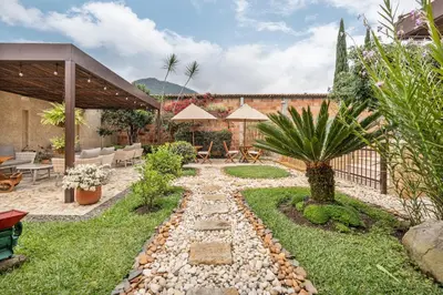 a garden with a stone path and a patio at Casa Passiflora Hotel Boutique - Jardín in Jardin