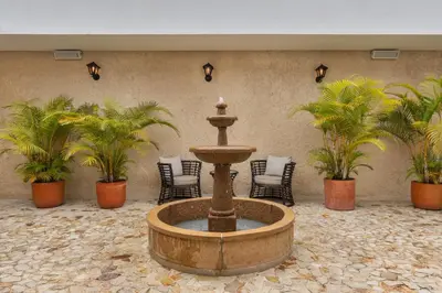 a fountain in a courtyard with chairs and palm trees at Casa Passiflora Hotel Boutique - Jardín in Jardin