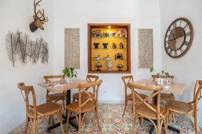 a restaurant with two tables and chairs and a clock at Casa Passiflora Hotel Boutique - Jardín in Jardin