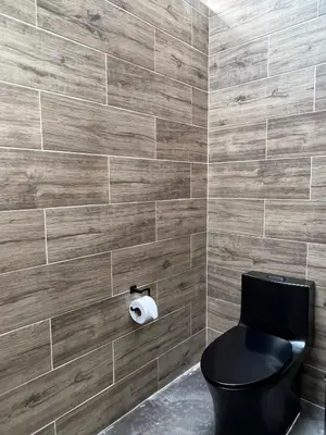 a bathroom with a black toilet and a roll of toilet paper at La Manola Finca Hotel in Doradal
